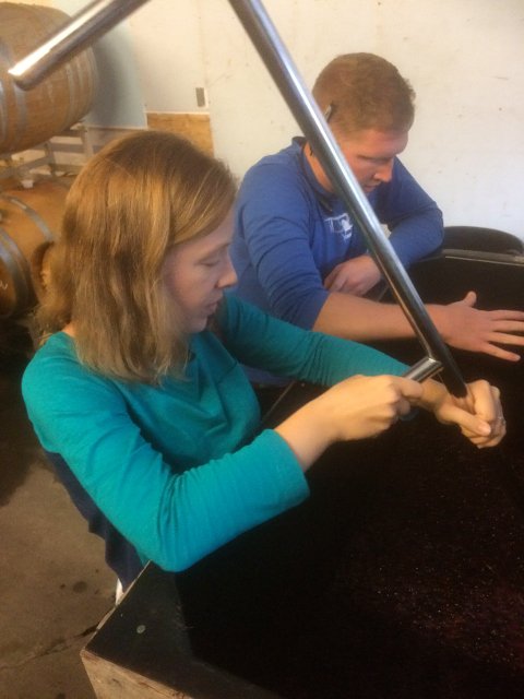Abby and Scott stirring the wine at Barnstormer Winery